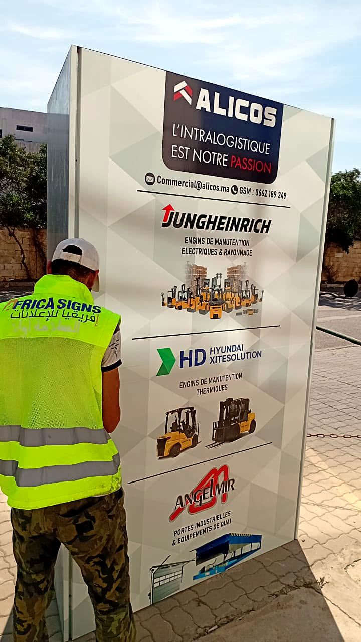 Totem Alicos en cours de pose par un technicien Africa Signs